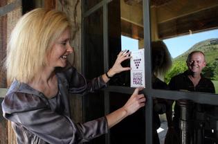 Lucy Chambers puts up a sticker at Church Rd Winery